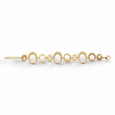 overview of a geometric bracelet opened
Product type: bracelet
Material:  18K Gold Filled, stainless steel base
Color: yellow gold
Style: statement, geometric, elegant, modern
Design details: hammered open circle and oval links, graduated sizes, textured finish, airy openwork design, lobster clasp with extender
Best for: statement styling, special occasions, everyday elevated wear, gifting, artistic jewelry lovers