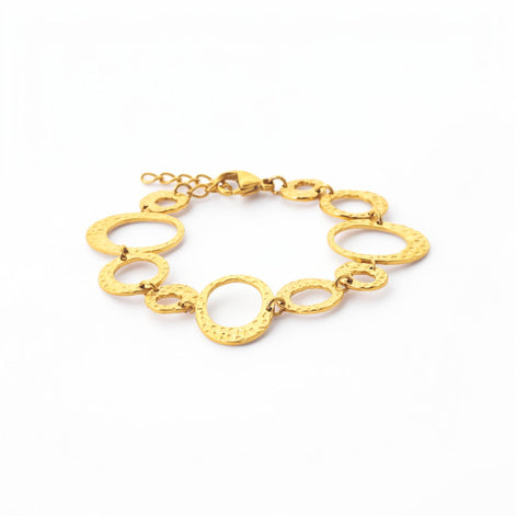 overview of a geometric bracelet closed
Product type: bracelet
Material:  18K Gold Filled, stainless steel base
Color: yellow gold
Style: statement, geometric, elegant, modern
Design details: hammered open circle and oval links, graduated sizes, textured finish, airy openwork design, lobster clasp with extender
Best for: statement styling, special occasions, everyday elevated wear, gifting, artistic jewelry lovers