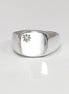 Peut inclure: Une bague signet en argent avec un petit diamant clair serti au centre en forme d'étoile.