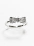Peut inclure: Une bague en argent avec un motif en forme de nœud orné de petites pierres claires.