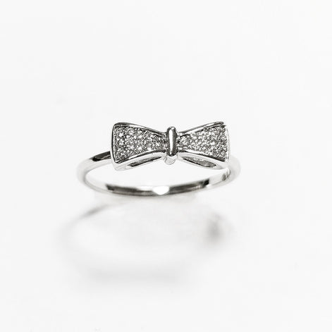 Peut inclure: Une bague en argent avec un motif en forme de nœud orné de petites pierres claires.