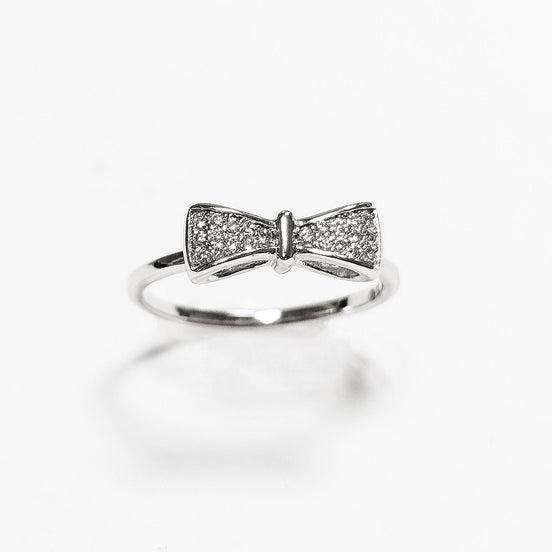 Peut inclure: Une bague en argent avec un motif en forme de nœud orné de petites pierres claires.