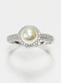 May include: A silver ring with a central, cream-coloured pearl surrounded by a halo of small, clear gemstones. The ring's band is also set with similar gemstones, creating a sparkling effect. The ring is displayed against a white background.