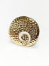 Peut inclure: Une bague dorée avec une texture martelée et un motif tourbillonnant blanc. La bague est de forme circulaire avec un détail en spirale. Le bijou est un accessoire de déclaration, sur fond blanc.