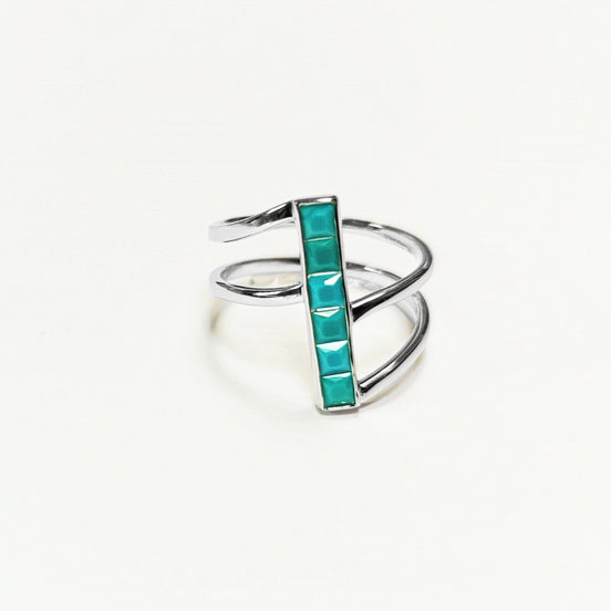 Peut inclure: Une bague en argent avec une pierre turquoise sertie dans un design de barre verticale. La bague a un design à triple bande.