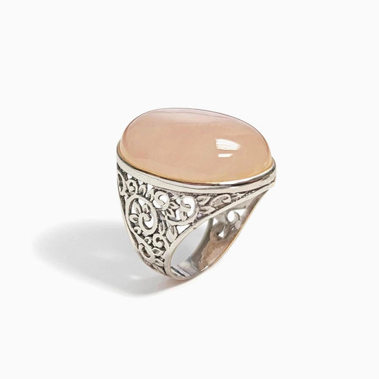 Peut inclure: Bague en argent ornée d'une pierre précieuse ovale rose pâle. La bague présente un motif filigrané élaboré sur le corps. La pierre est sertie dans un simple sertissage.