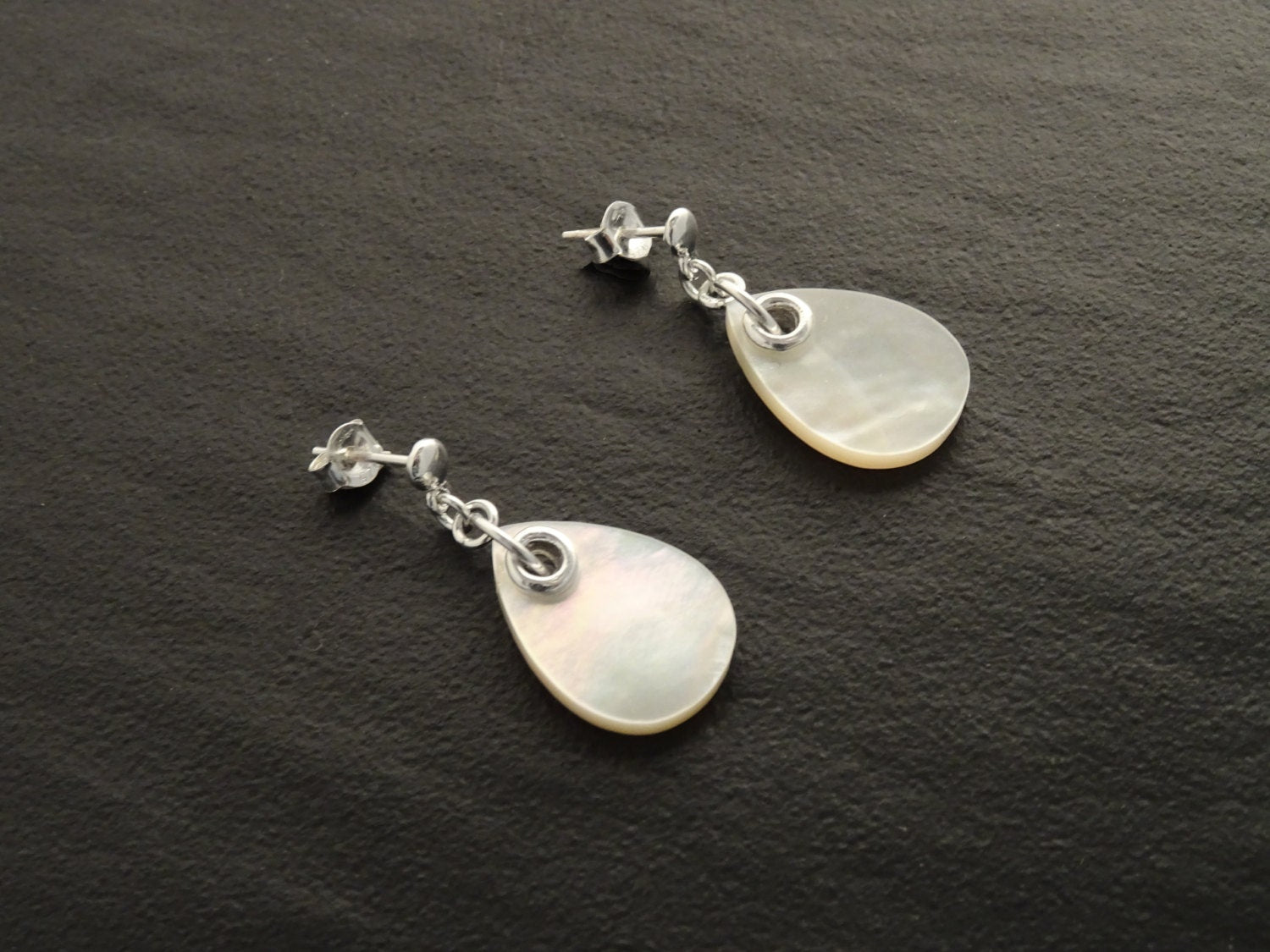 Une paire de boucles d'oreilles en argent avec des pendentifs en nacre blanche en forme de larme. Boucles d'oreilles de qualité, fabriquées à la main, par des petits créateurs de bijoux locaux reconnus (des milliers de ventes), avec des matériaux de qualité et durable. Un achat en toute confiance dans une boutique avec des milliers d'avis positifs.