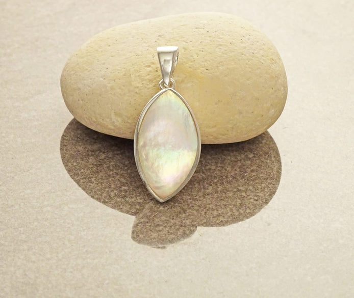 Un pendentif en argent de forme amande ovale serti avec de la nacre blanche. Un bijou moderne fait main par des créateurs locaux avec des matières durables dans une Boutique fiable pour un achat sécurisé.