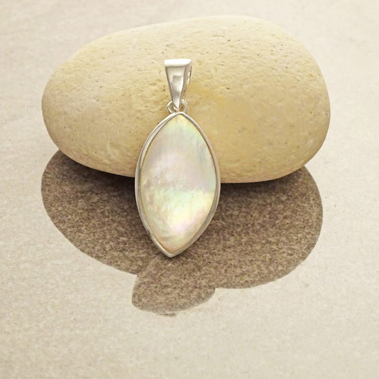 Un pendentif en argent de forme amande ovale serti avec de la nacre blanche. Un bijou moderne fait main par des créateurs locaux avec des matières durables dans une Boutique fiable pour un achat sécurisé.