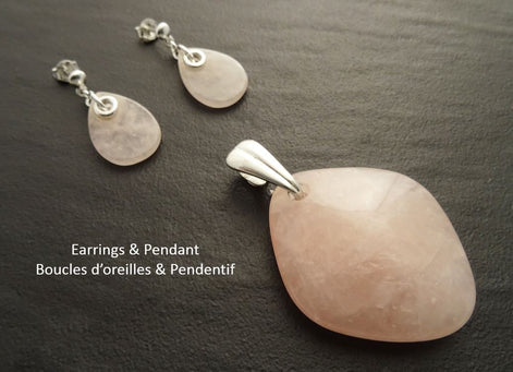 Une paire de boucles d'oreilles et un pendentif en quartz rose. Les boucles d'oreilles sont en argent 925 avec une pierre de quartz rose en forme de goutte. Le pendentif est une pierre de quartz rose plus grande et de forme ovale avec une bélière en argent 925.