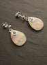 Une paire de boucles d'oreilles en argent 925 avec des pierres de quartz rose en forme de goutte.